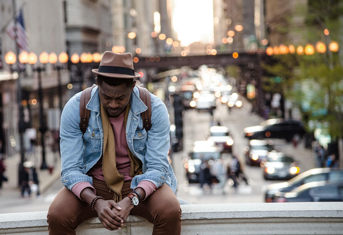 man sitting in city can't sense or feel God